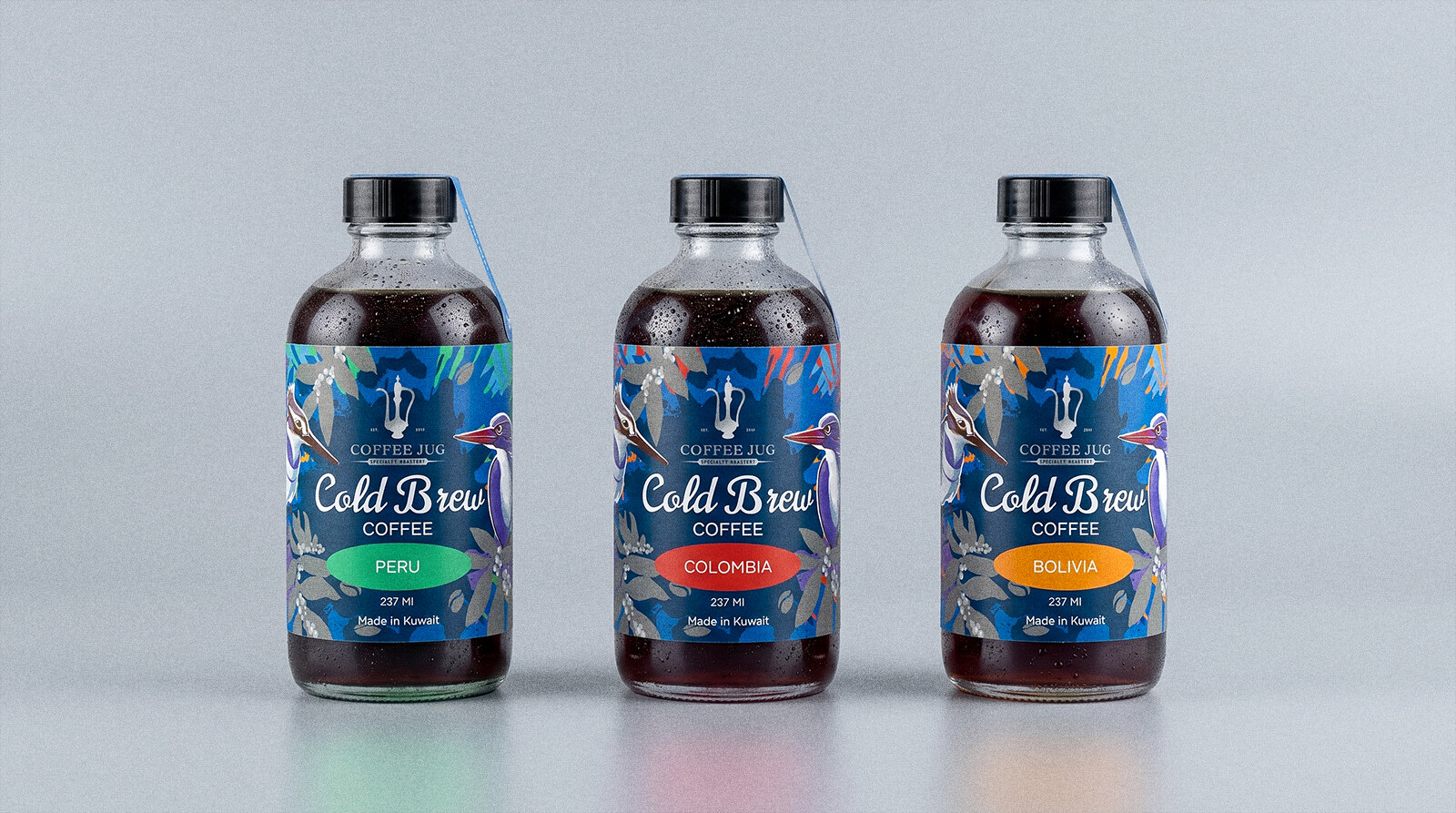 The same three cold brew bottles on a plain grey studio background, labels shown clean