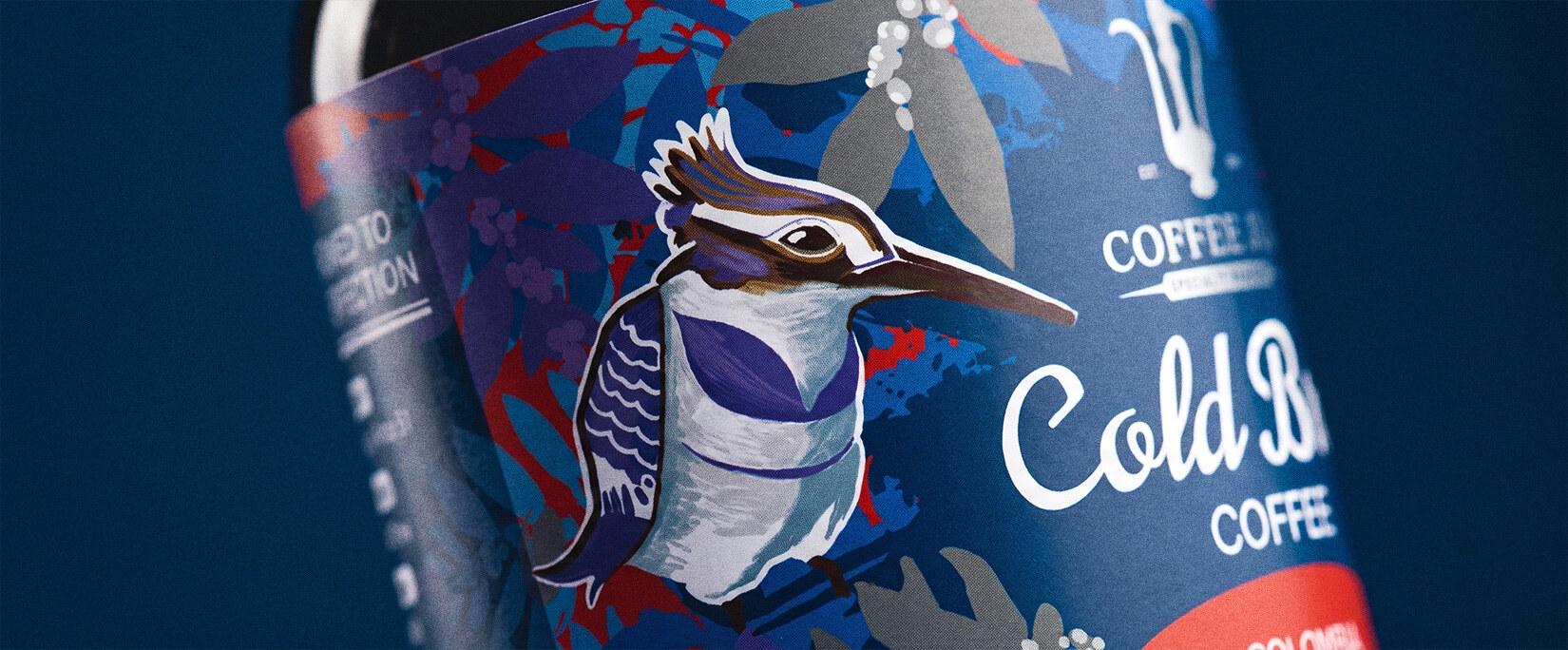 Macro of the kingfisher label detail — violet crest, white breast, red bill
