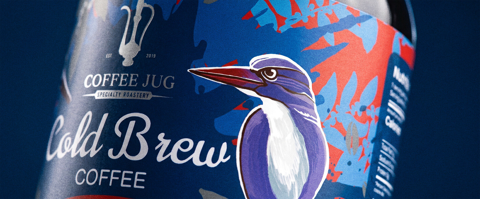 A closer crop on the kingfisher's head against the label's red and blue splatter pattern