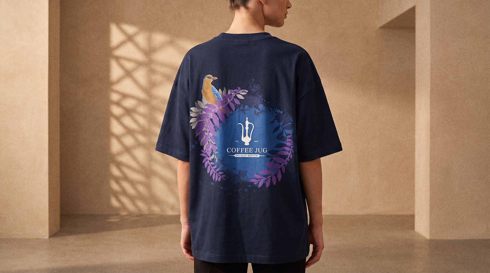 An oversize Coffee Jug tee worn, the bird-and-foliage print centred on the back