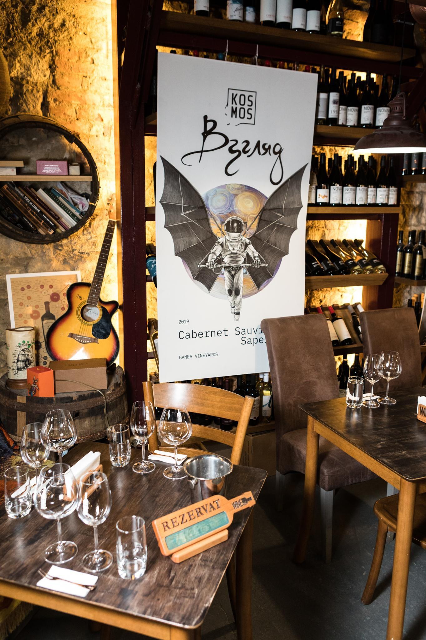 Взгляд roll-up banner standing in a wine bar, beside a shelf of bottles