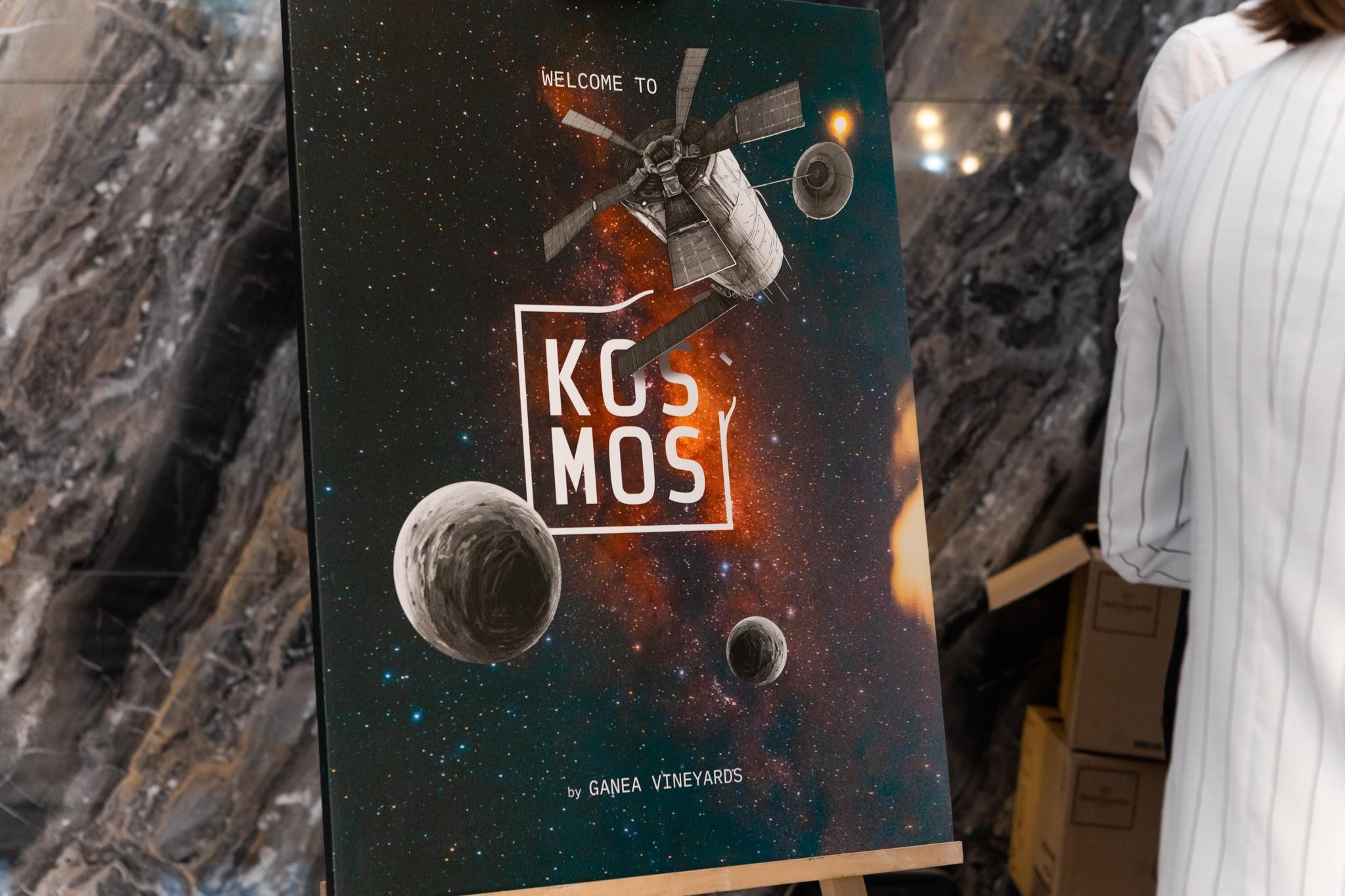 A “Welcome to Kosmos” easel poster with the satellite illustration