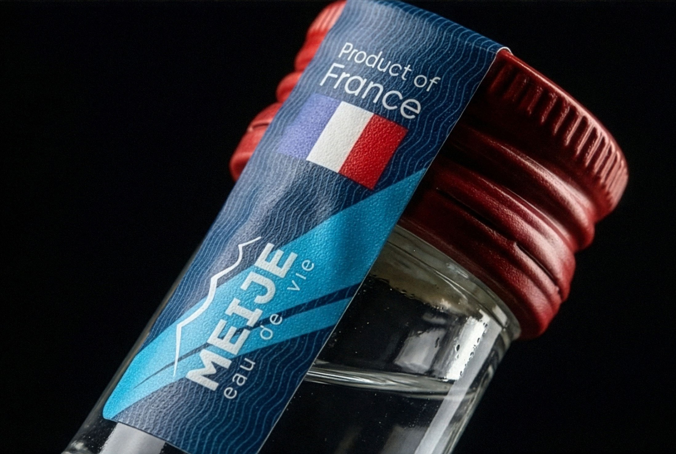 The neck label in close-up, Product of France over a mountain silhouette
