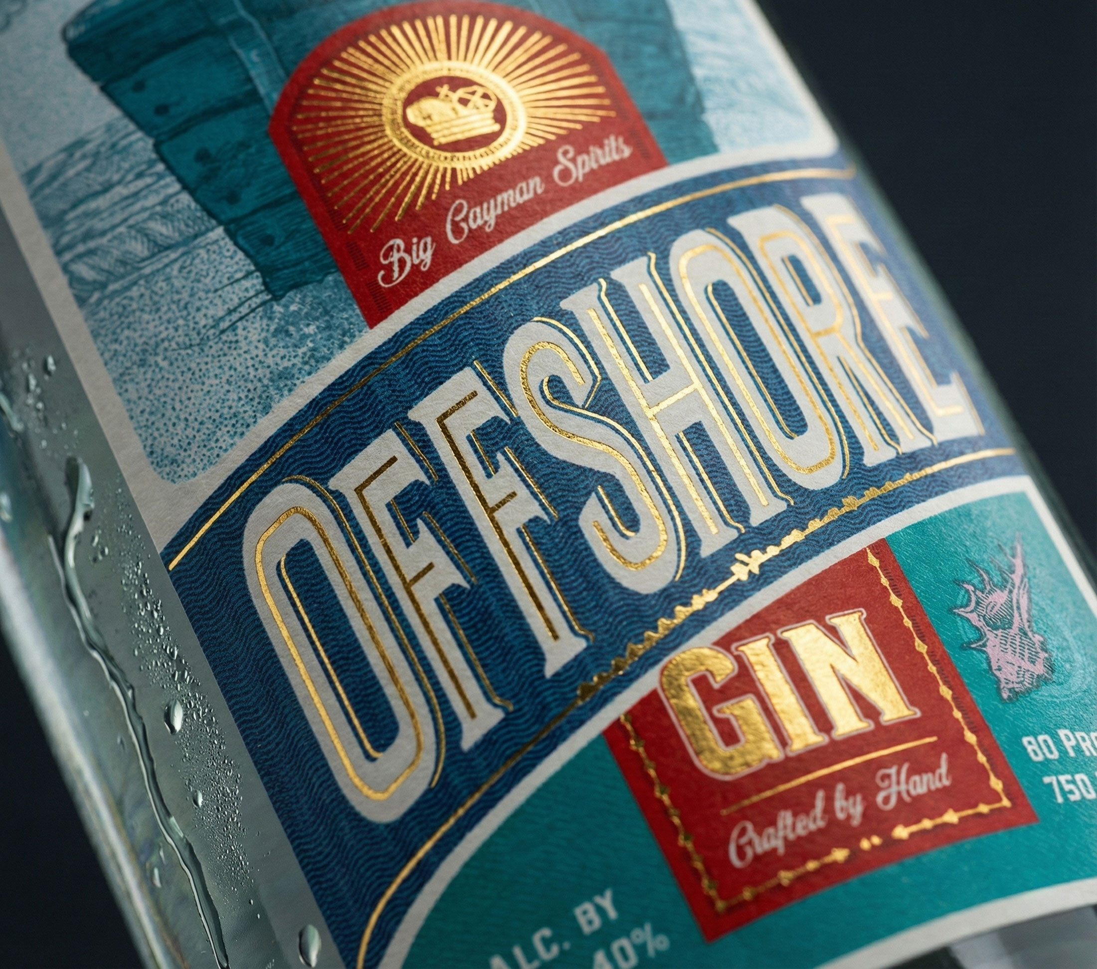 Close-up of the OFFSHORE lettering, gold foil over a wave-pattern guilloché, with the crest and GIN panel