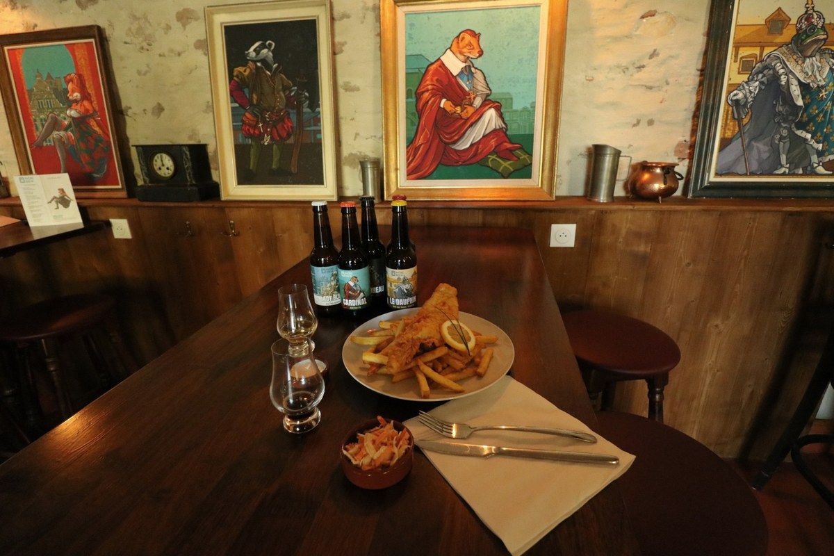 The cast hanging on the taproom wall in gilt frames, on medieval stone