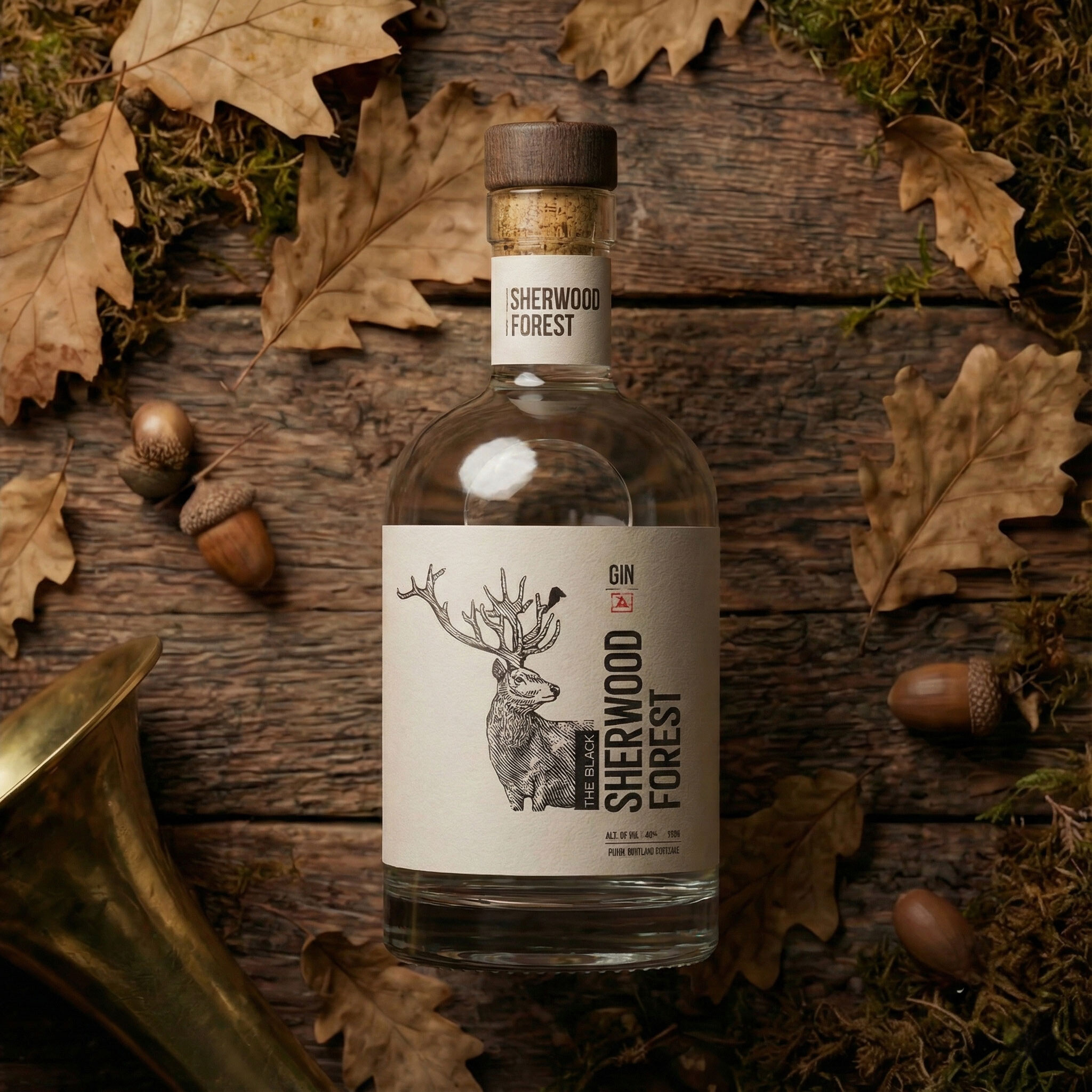 Overhead flat-lay of the bottle among oak leaves, acorns, moss and a brass horn