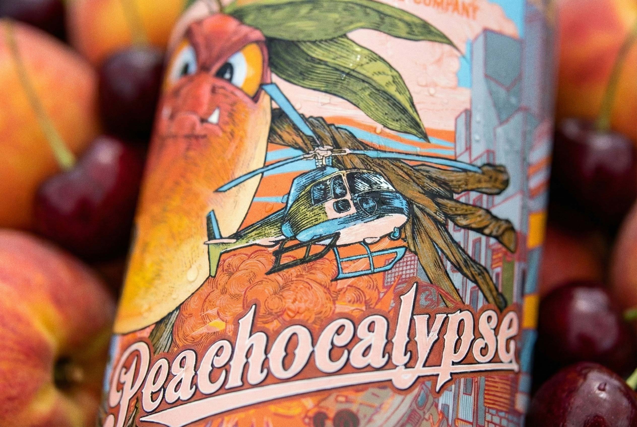 Macro of the Peachocalypse peach gose can — a snarling peach and a helicopter over a burning city, packed with detail