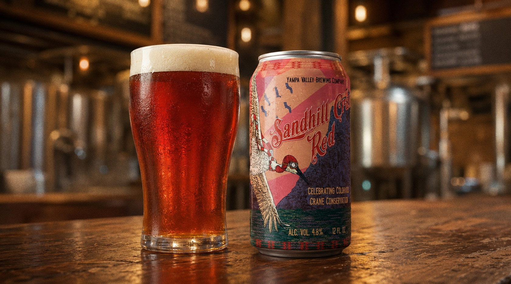 Sandhill Crane Red — the can on the bar beside a poured glass of red ale, the engraved crane on the label